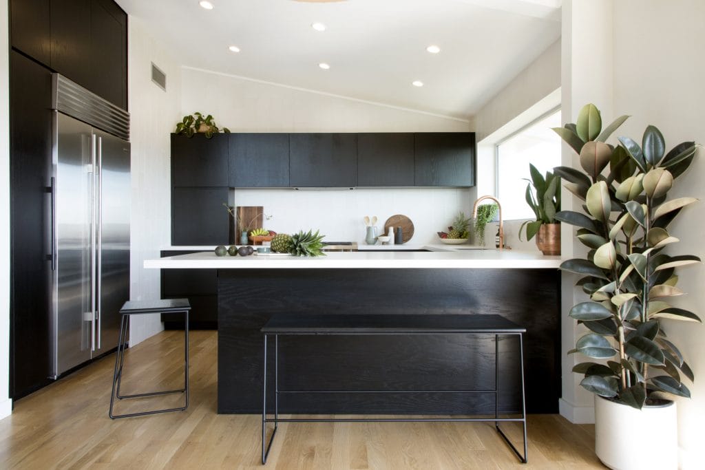 Black kitchen cabinets in a small kitchen create a dramatic look by Decorilla