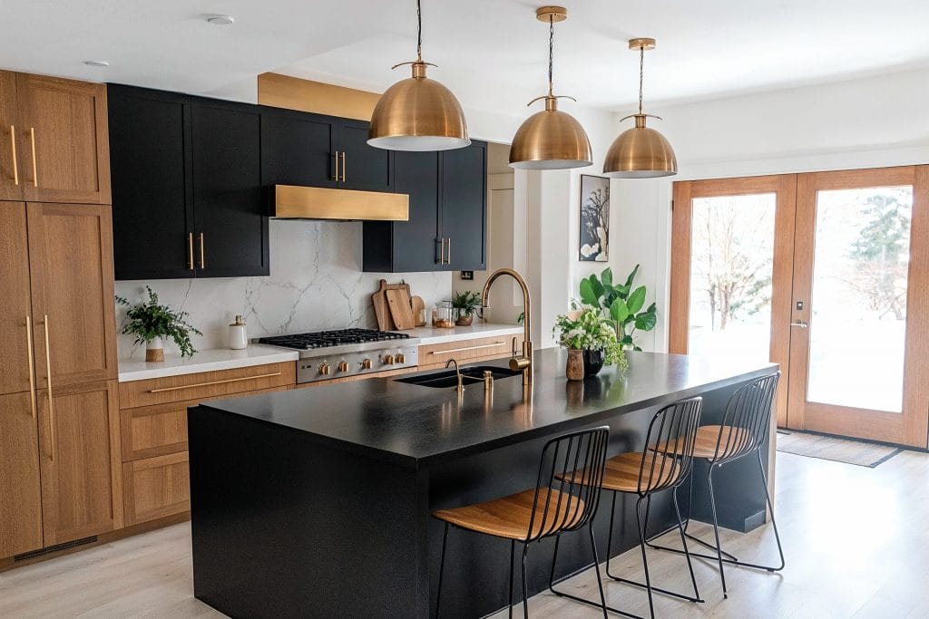 Minimalist kitchen with a gold decorative hood vent by DECORILLA