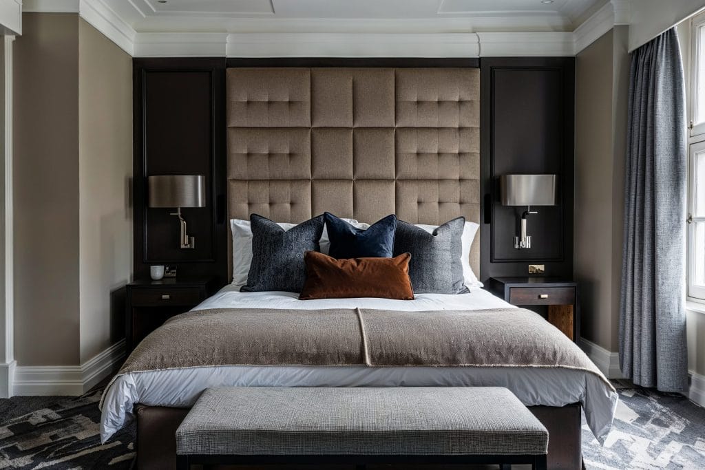 A sleek neutral headboard anchors this modern neutral bedroom design by Decorilla