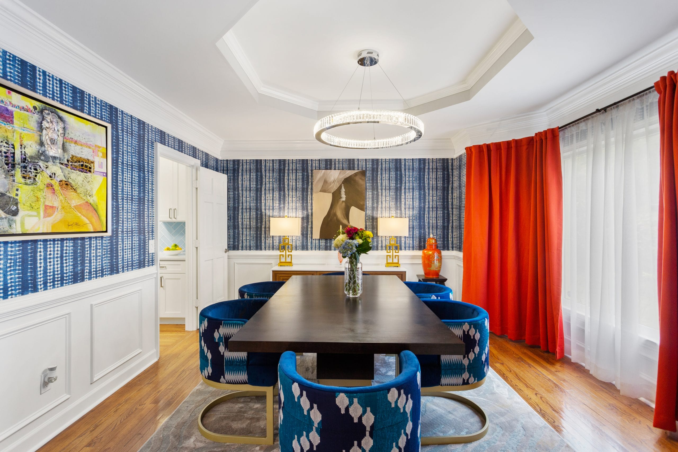 Contemporary dining room with bold red chairs, by Decorilla designer Sierra G. 