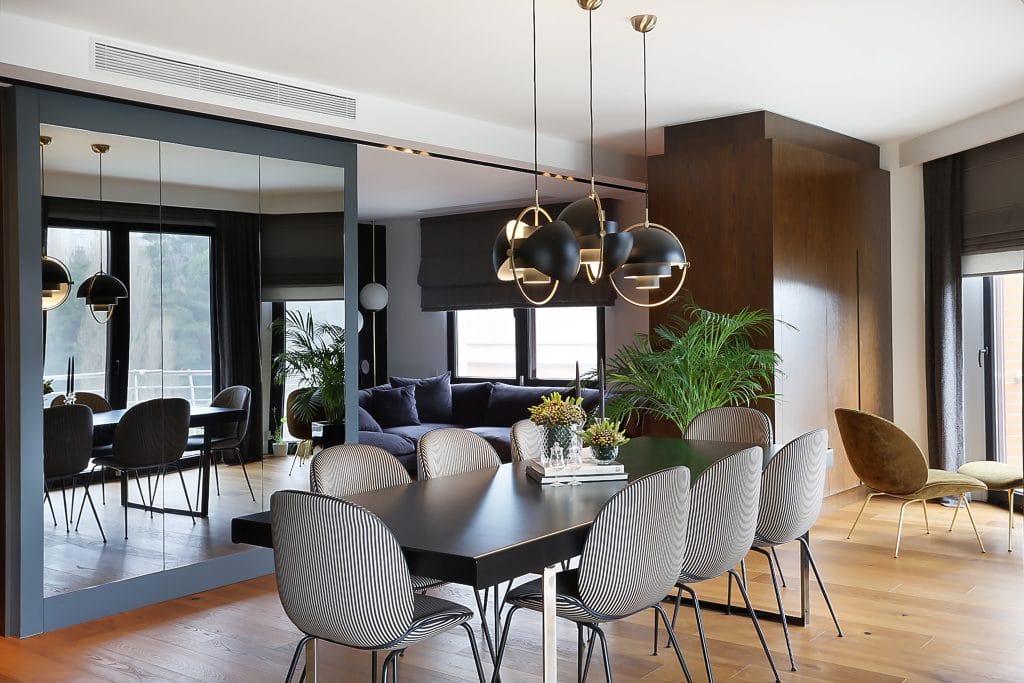 Contemporary dining room with feature mirror wall by DECORILLA